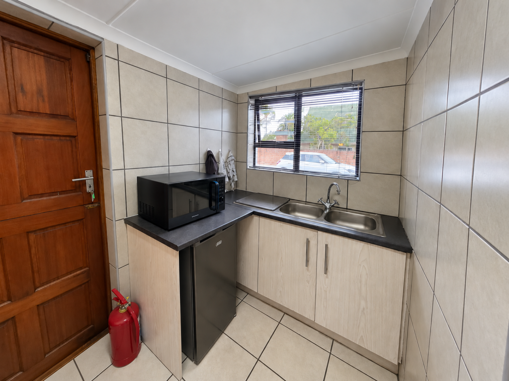 Neat Compact Kitchenette with Window Views